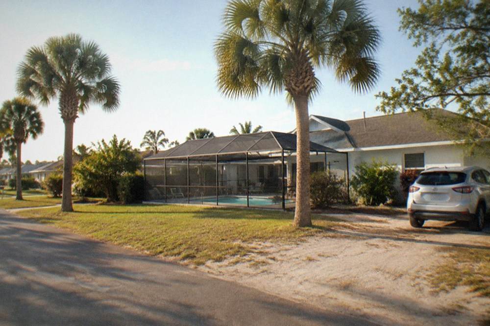 Vacation home with a screened pool and palm trees on a quiet residential street in Central Florida