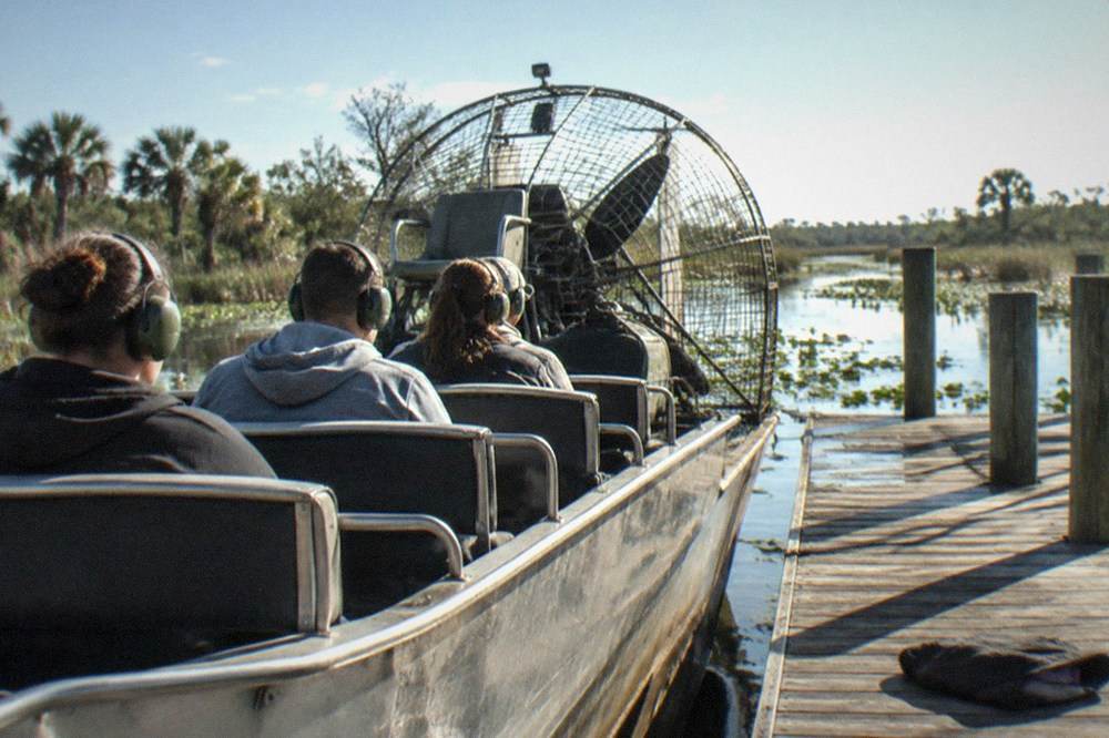 Passengers wearing ear protection seated on an airboat bench