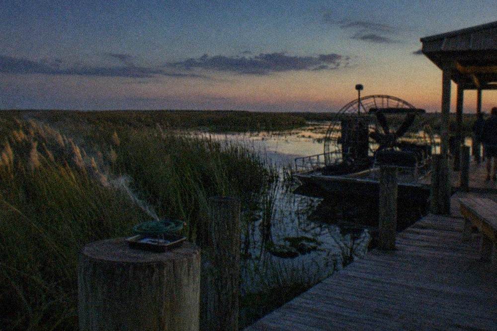 A wide Florida marsh at dusk with tall grasses and open water stretching to the horizon