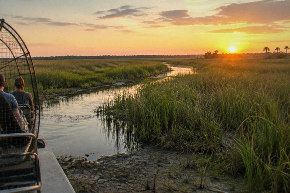 Wide shallow Florida marsh at golden hour with grass standing above low water