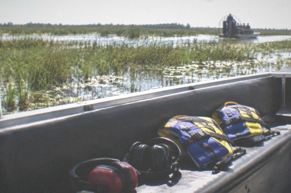 Life vests and earmuffs stowed on an airboat bench seat before boarding