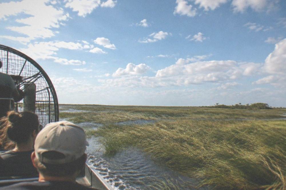 Wide open sawgrass marsh and shallow water stretching to a flat horizon under a big sky