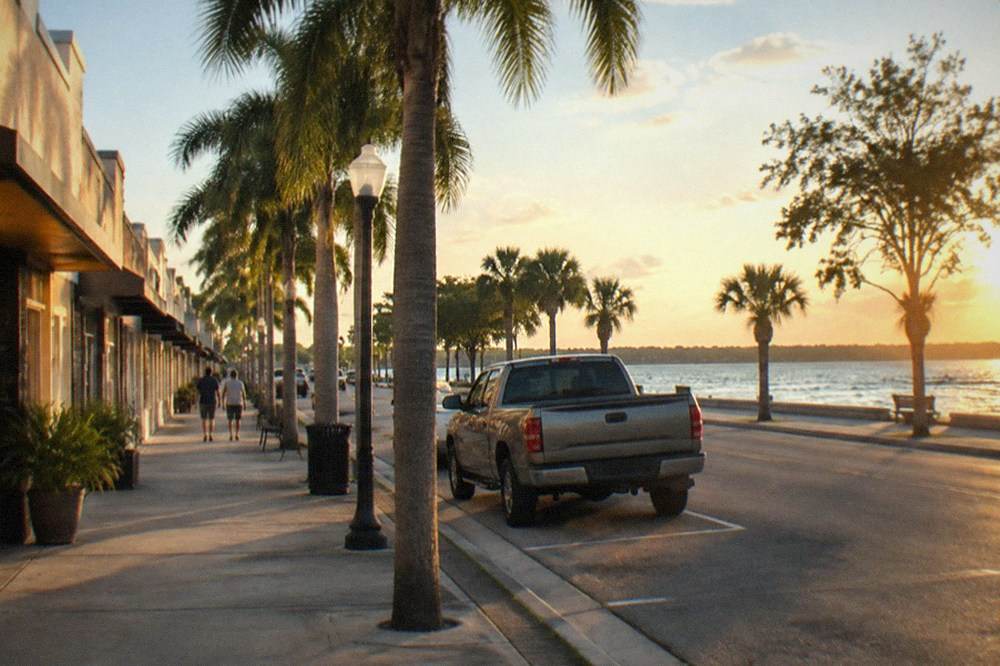 A downtown lakeside street in a small Florida city with palm trees